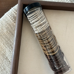 Neutral Morandi earth-tone elastic hair ties set in a transparent storage tube