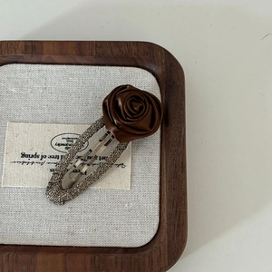 Elegant vintage brown rose hair clip with glitter base on display tray for women