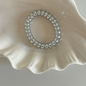 Élastique à cheveux spirale argenté métallisé dans une coupelle en céramique