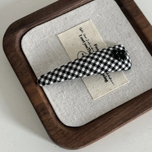 French vintage black and white houndstooth hair clip with beaded flower on linen backdrop