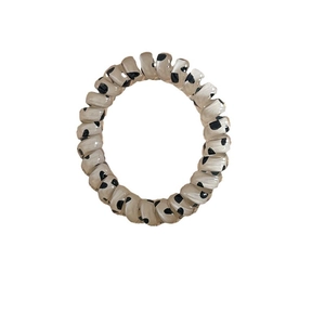 Élastique à cheveux spirale motif lait de vache avec pois noirs sur fond blanc