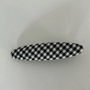 Detailed macro view of the black and white houndstooth fabric texture on an oval hair clip