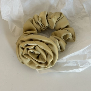 Chouchou élégant en satin champagne doré avec rose 3D sur fond de papier froissé
