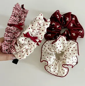 Detail of red and white polka dot and plaid fabric scrunchies with bow design