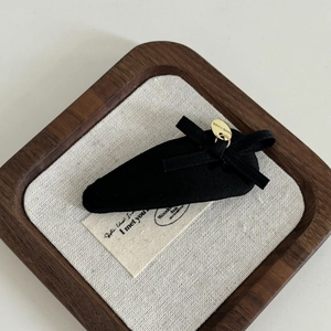 Elegant black bow hair clip with gold handmade pendant on a minimalist headband