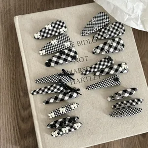 Detailed close-up of 15-piece plaid bow hair clip set with handmade embroidery