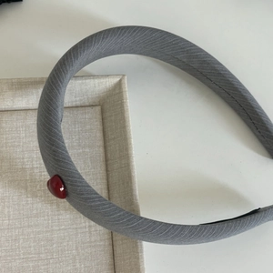 Grey striped fabric headband with red heart ornament and black anti-slip inner lining
