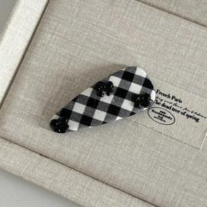 Close-up of black and white checkered fabric BB clip with three small resin bows