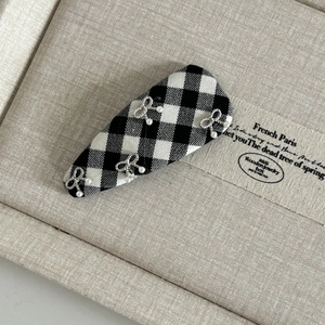 Detail of British style plaid hair clip with silver bows and white imitation pearls
