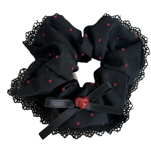 Black scrunchie with red polka dots featuring a bow and heart-shaped pendant