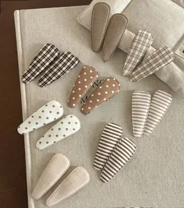 Close-up of 12 handmade brown fabric BB hair clips with polka dots and plaid patterns