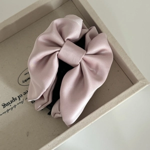 Elegant large pink satin bow hair claw clip with glossy silk texture for women