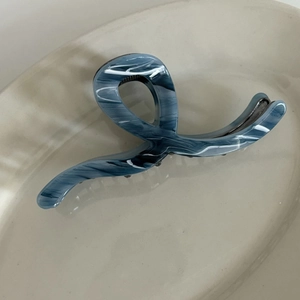 Close-up of gray marble ink pattern on acetic acid shark clip with a spiral design