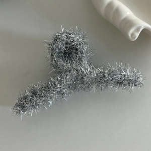 Pince à cheveux en fil métallique argenté avec texture duveteuse et fini brillant