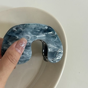 Detailed macro view of large blue and white marble pattern acetate hair claw clip