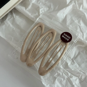 Vue détaillée de trois pinces à cheveux ovales BB beige dans un emballage artisanal