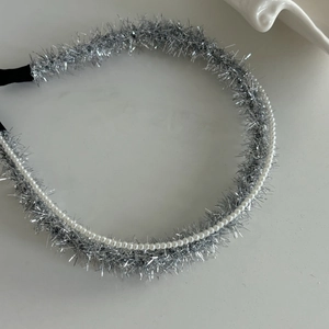 Serre-tête en fil métallique argenté orné de perles blanches sur fond gris clair