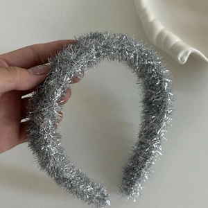 Détail de la texture argentée scintillante sur un serre-tête flexible pour femme