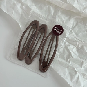 Lot de trois barrettes ovales marron thé au lait avec finition brillante sur papier blanc