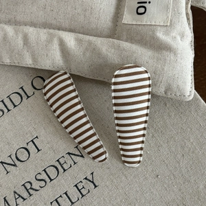 Close-up of handmade brown striped BB hair clips on natural canvas background