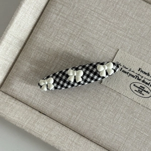Detail of British style houndstooth hair clip with three white 3D resin bows