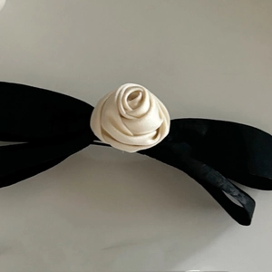 Elegant French style black satin bow hair clip featuring a cream fabric rose centerpiece