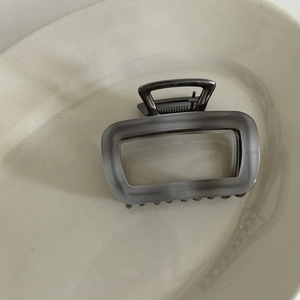 Detail of grey ink-pattern acetate hair claw clip with frosted rectangular frame