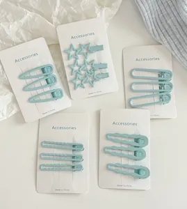 Vue détaillée de barrettes à cheveux en métal bleu clair en forme de goutte et d'étoile