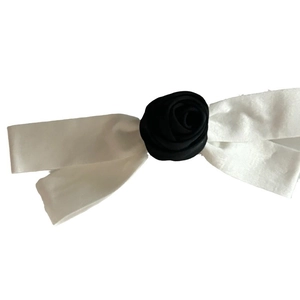 French style bow hair clip with a black rose center and white satin ribbons on white background