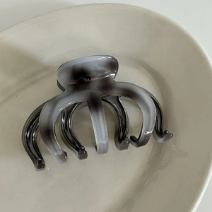 Detailed view of the marble ink pattern and smooth texture on the grey acetate hair claw