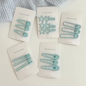 Cinq ensembles de barrettes à cheveux en métal bleu menthe aux formes variées sur carte