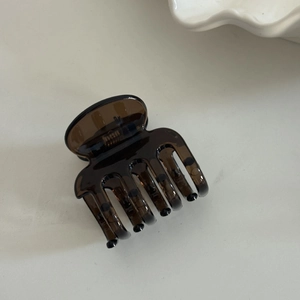 Detail view of a large amber resin hair claw clip on a clean white surface
