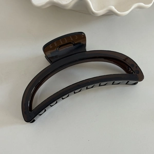 Detail of amber translucent large shark hair claw clip with strong black metal spring