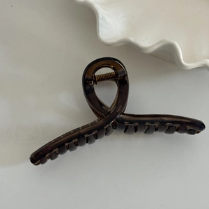 Detail of a large amber translucent hair claw clip made of high-quality acrylic material