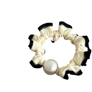 Elegant off-white lace hair scrunchie with black wavy trim and large faux pearl detail