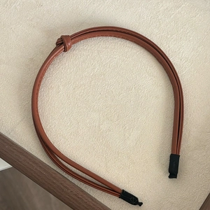 Detail of brown double-strand knotted PU leather headband with comfortable fabric tips