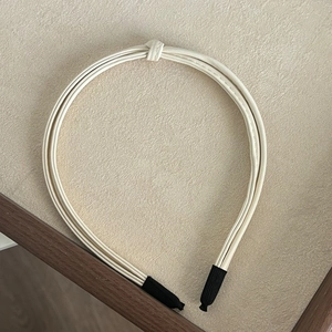 Detail of cream multi-strand knotted PU leather headband with comfortable black protective tips