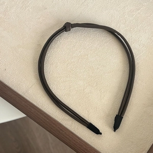 Detailed top view of dark brown multi-strand PU leather headband with a central knot