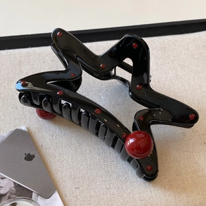 Star shaped black hair claw clip with red polka dots and large red pearl accents