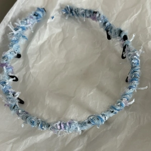 Dettaglio della fascia intrecciata azzurra con filato ondulato e fibre pelose
