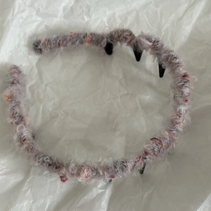 Dettaglio di fascia per capelli in maglia colorata con denti interni in plastica antiscivolo
