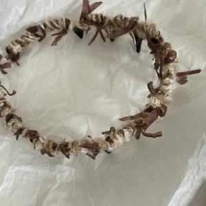 Dettaglio macro della trama in maglia marrone su un cerchietto a zigzag in stile bohémien