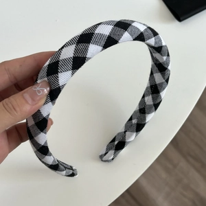 Close-up of black and white houndstooth headband with vintage fabric texture details