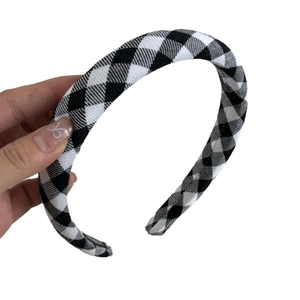 Classic black and white houndstooth headband with plaid fabric texture and elastic design