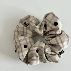 Detail of beige plaid scrunchie with red green checks and black polka dot bow print