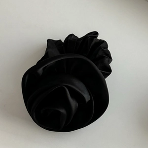 Elegant black satin rose flower hair scrunchie with a silky finish on white background