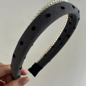 Detail of grey polka dot fabric headband with white faux pearl embellishments