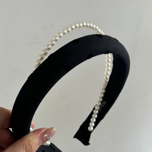 Detail of grey double-layered headband set with pearls and textured fabric bow