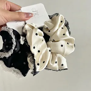 Handmade lace polka dot scrunchie set in black and white silk for elegant ponytails