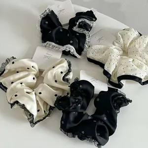 Detailed view of polka dot lace scrunchies on handmade display cards in black and white